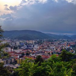 View of cityscape against cloudy sky