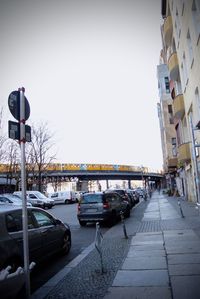 Cars on street by buildings against sky