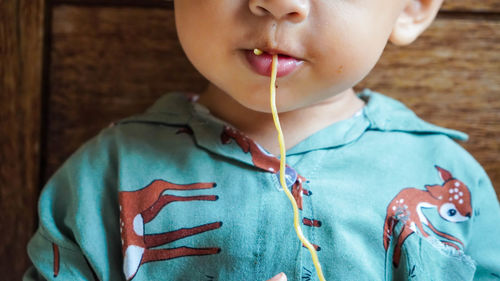 Close-up of boy eating noodles