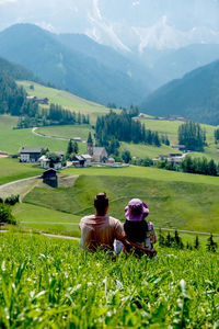 Rear view of men on field against mountains