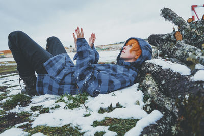 Man sitting on snow covered field