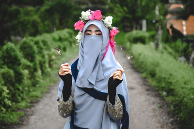 Portrait of woman with umbrella standing on land