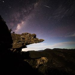 Low angle view of rock formation against sky at night