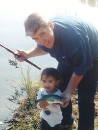 Portrait of father and son holding baby