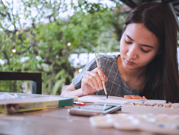 Girl painting on paper over table