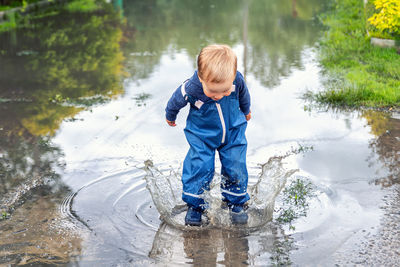 Full length of boy standing on puddle