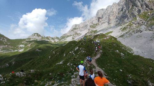 People photographing on mountain against sky