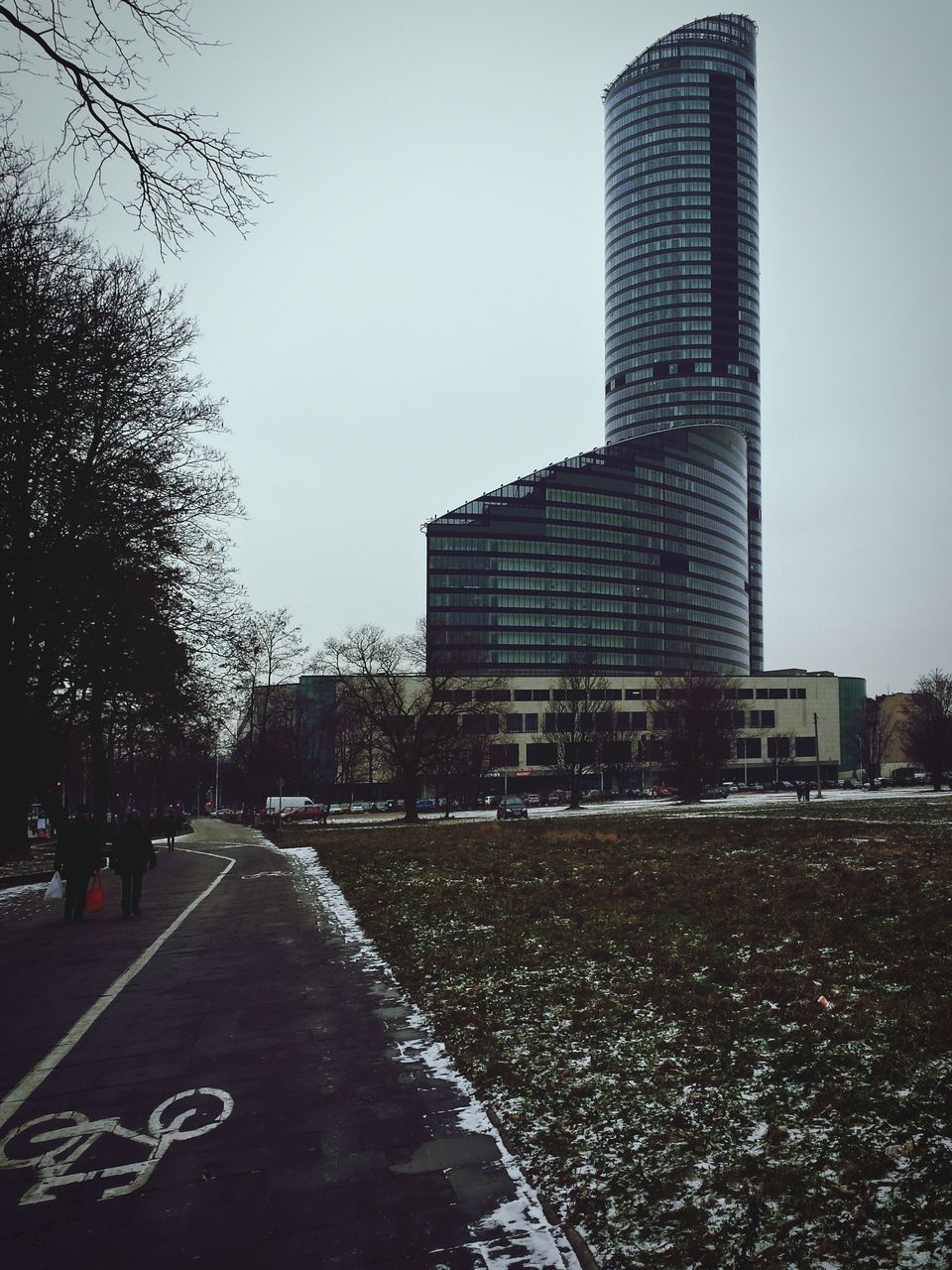 building exterior, architecture, built structure, the way forward, city, road, clear sky, transportation, street, sky, road marking, diminishing perspective, building, tower, day, vanishing point, skyscraper, outdoors, tree, tall - high