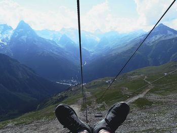 Low section of person on mountain against sky