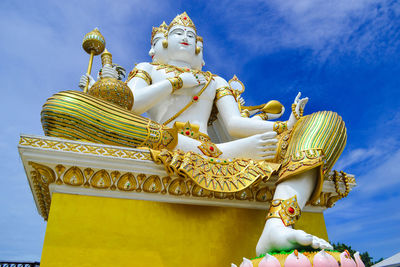 Low angle view of statue against temple against sky