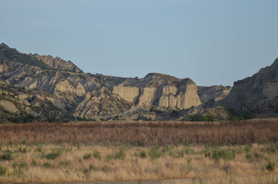 Scenic view of landscape and mountains against clear sky