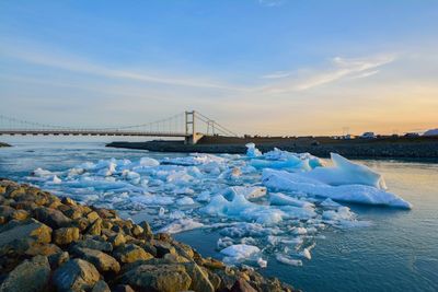 View of suspension bridge over sea against sky