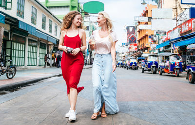 Friends walking on street in city