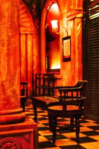 Empty chairs and tables in illuminated building