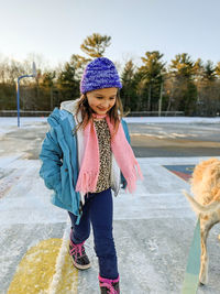 Smiling girl walking in playground during winter