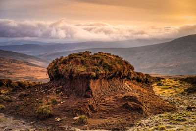 Rock formation on landscape against sky during sunset