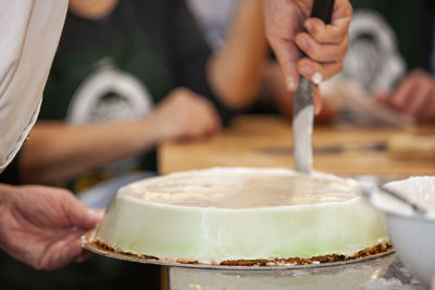 Midsection of person preparing cake