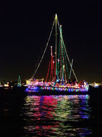 Illuminated suspension bridge over river at night