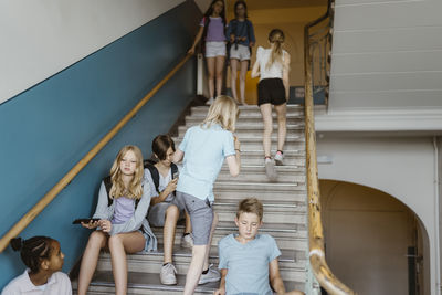 Male and female students on staircase during recess at school