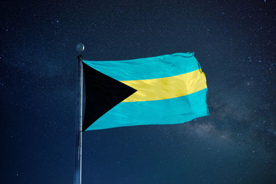 Low angle view of flag against blue sky