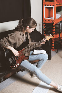 Full length of woman playing guitar