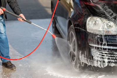 Cropped image of man washing car at garage