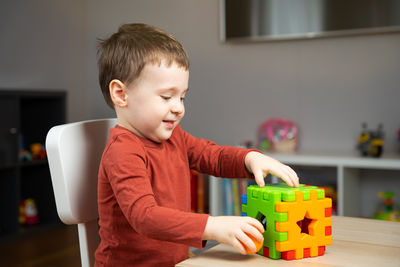 Portrait of cute girl playing with toy blocks at home