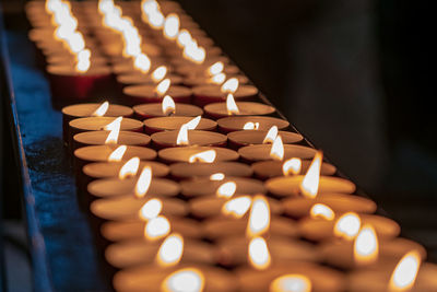 Close-up of illuminated candles in temple