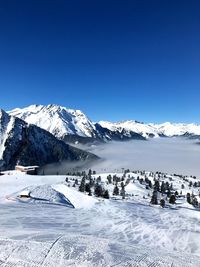 Scenic view of snowcapped mountains against clear blue sky