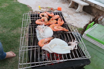 High angle view of person preparing food on barbecue grill