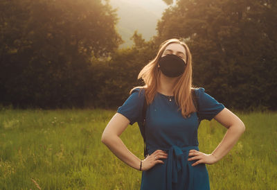 Young woman wearing sunglasses standing on field