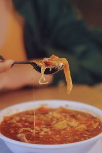 Close-up of hand taking a spoon of  mexican food 