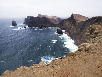 High angle view of rocky coastal feature against sky