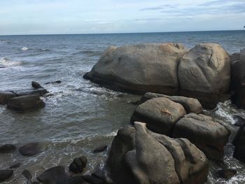 Rocks on sea shore against sky