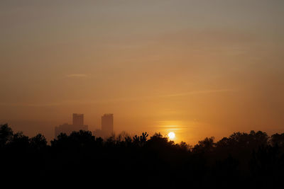 Silhouette buildings against sky during sunset