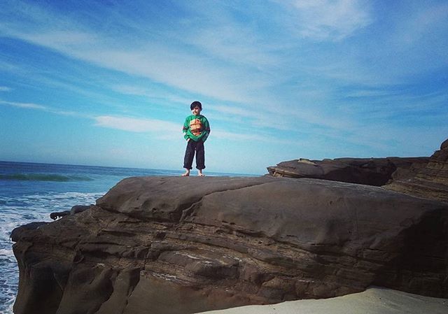 full length, sea, lifestyles, leisure activity, sky, water, standing, rock - object, casual clothing, horizon over water, rear view, young adult, tranquility, tranquil scene, beauty in nature, scenics, nature, vacations