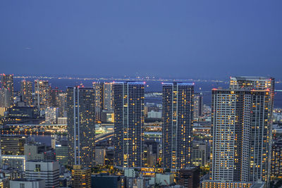 Illuminated cityscape against clear sky