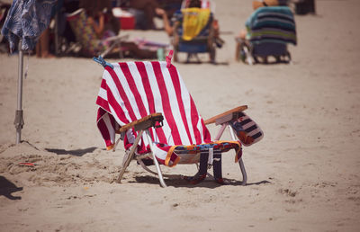 Empty chairs on sand at beach