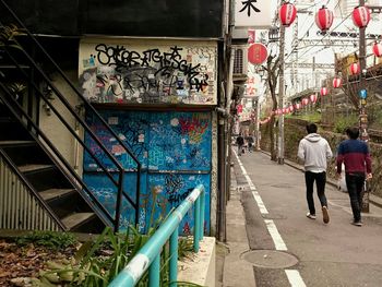 Rear view of people walking on footpath