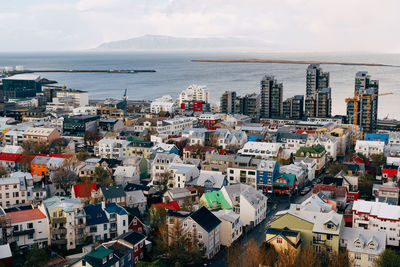 High angle view of townscape by sea against sky