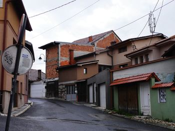 Road amidst buildings against sky