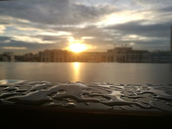 Surface level of river against sky during sunset