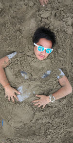 High angle view of man wearing sunglasses on beach