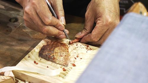 Midsection of man working on cutting board