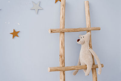 Soft toy bear sits on a wooden staircase in the decor of the children's room