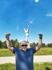 Portrait of man wearing sunglasses standing against sky