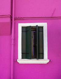 Low angle view of pink window on building