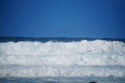 Scenic view of sea against clear blue sky