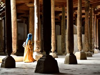 Woman walking by columns in building