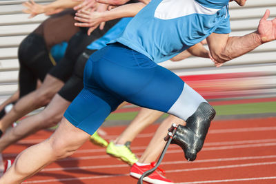 Low section of people running on sports field